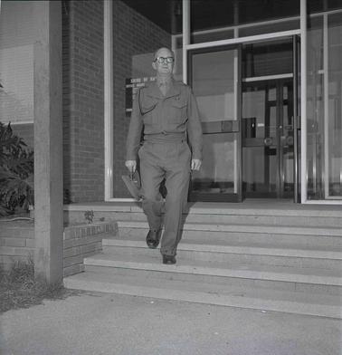 Man in military uniform descending down some steps.