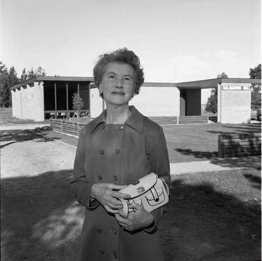 A woman holding a handbag posing for photo in front of the Balnarring Hall.