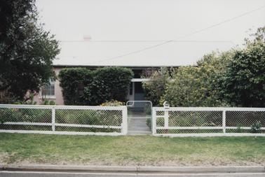 Single storey building, covered in cladding. It has sash windows and a metal roof. One chimney is visible.