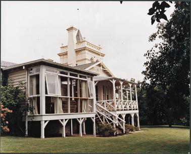 A colour image of the external view of a large house known as “Southdean”, the photo has been taken from the front showing the later additions to the house, the tower can be seen in the background