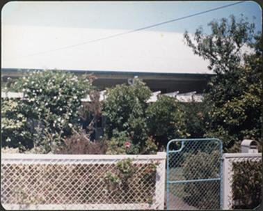 This image only shows the slanting roof of the residence with a wire fence divided by a gate in the front
of the building
