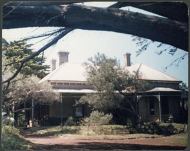 A front view of Bella Vista,  the image showing the verandah, bay window on right and three chimneys