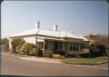 A white weather board residence with three chimneys and a part verandah