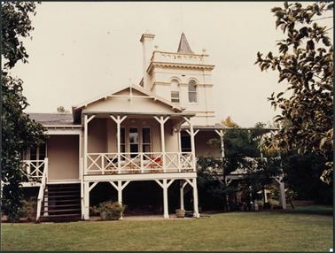 A front view of Southdene with tower and elevated timber verandahs white stone and masonry 
a pictureseque Gothic style building