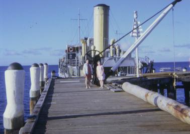 Rye Pier with South Channel dredge located at the end of the Pier.  Two ladies - Dorothy Earles (nee Hill) and Joan Ormesher (nee Woollard) standing in front of the dredge.