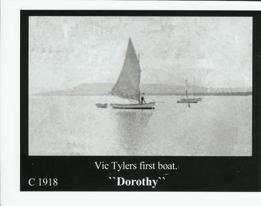 Black and White photograph of Vic Tyler on his first boat “Dorothy”.  Arthur’s Seat in the background.