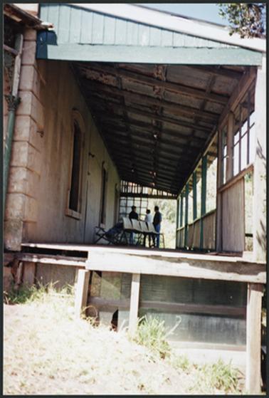 A front view of ‘Bella Vista’ showing the hipped verandah, wooden posts, part filled in on southern edge, detail of corner of stuccoed house and partial view of cellar photo taken on the day of the auction 13 Feb 1994