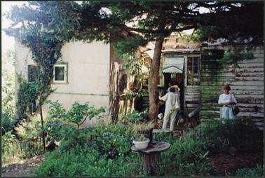 Outside rear view of the home ‘Bellavista’ with stucco section on left, and in poor condition wooden
addition to the right of the building, garden and tree in foreground several people entering back door
taken on day of auction 13 Feb 2007