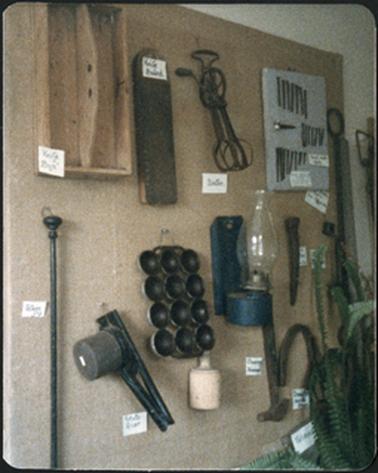 A view of various kitchen and farm implements on a wall display in the Old Post Office Museum