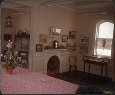 A view of the fireplace with a chair in front of it and to the left and right are display stands