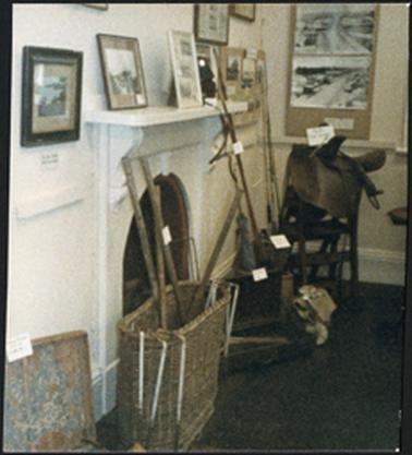Image of mantelpiece with pictures displayed and in the front croquet set and side saddle