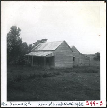 A side view of a wooden cottage with verandah and hipped roof since demolished
