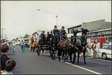 Colour image of Main Street Mornington depicting the Allison Monkhouse hearse drawn by two horses being driven past the Mornington Cinema on Australia Day 1995