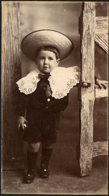 The image is of young Alfie Jarvie, in period clothes and straw hat with one hand on what appears to be a wooden gate