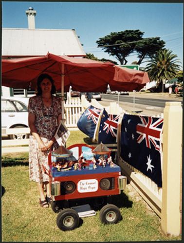 Maureen Tregonning standing behind the carousel outside the OPOM Mornington on Australia Day 2002