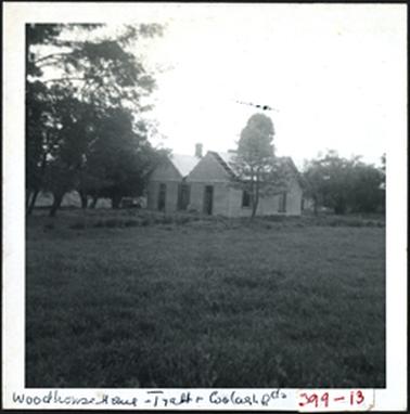 A hipped roof building with several windows, photographed from a distance