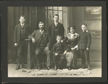 Portrait of Frank Unthank and Wife both seated, with their four sons photographed with them