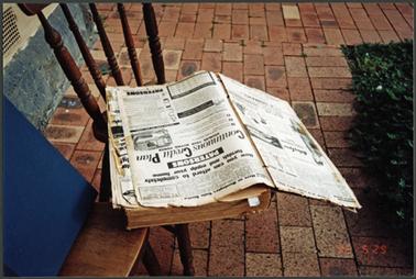 Collection of early newspapers in book form, page displayed open at furniture shop Patersons