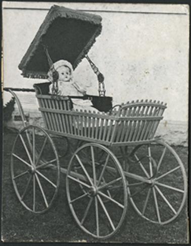 Heritage pram with hood open, doll sitting in the pram