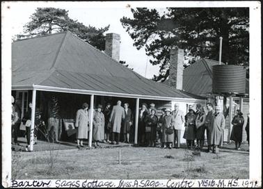 The image is of members of the Mornington Hist. Soc. standing under the verandah at Sages Cottage, Miss Annie Sage standing in the centre under the verandah (photo same as 427)