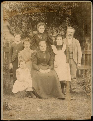 The image is of the Drayton family, mother, father, four daughters and one son, the image taken in a garden setting