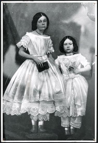 The image is of Annie Elizabeth and Emilie Freyer dressed in their best costumes for a special event