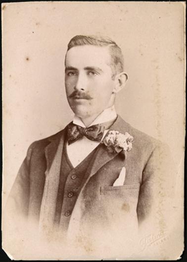 A head and shoulders portrait of Edward Firth, turned slightly to the left, dressed in waistcoat and overcoat,
bow tie and a flower in his coat lapel