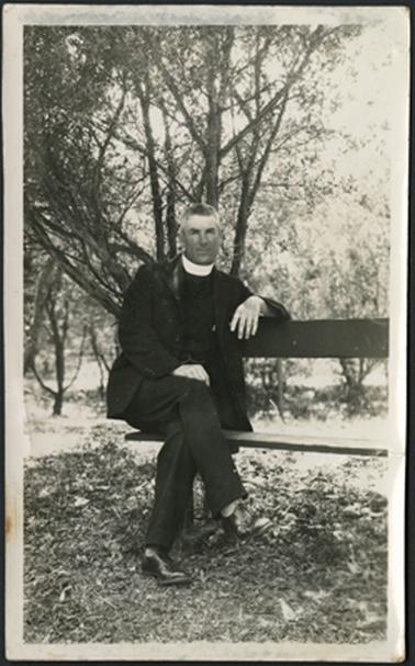 The image is of Rev E.I. Gason, Vicar, St Peters Mornington, photographed sitting on a seat in an outdoors setting. Vicar St Peters 1927-1936