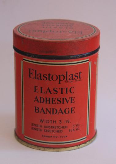 Round tin, red in colour, with black writing, containing elastic adhesive bandage used for medical purposes.