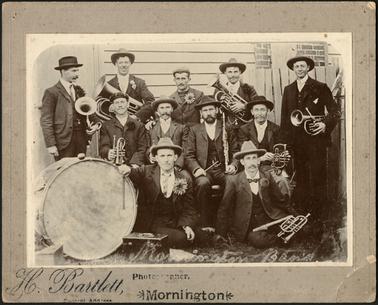 The image shows Band Members from Back Row Fred Parsons, Bert Wilson, ?LeFaye, Alec Beattie, Bob Stanley. Second Row Frank Harrup, George Beattie, George Jones (Bandmaster), Johnnie Simmons. Front Row Albert Connell, ?
