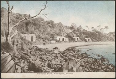 This postcard shows Fisherman Beach and seven beach huts bordering the beach. There are rocks shown in the foreground and a bushy embankment in the background.