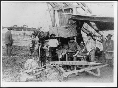 The image shows from left to right C. Allchin, two un-named children,  William Irons, Thomas Irons, Thomas Coxhell, James Johnston and an un-named  worker at the Mornington Brickworks