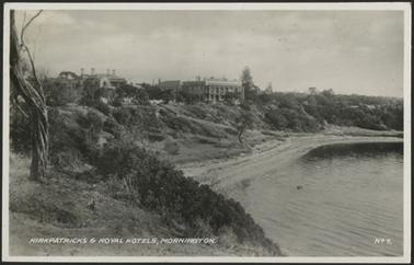 This image shows a view from the cliff top looking down on the beach, and with Kirkpatrick’s and The Royal Hotels clearly visible. The beach is deserted and the sea looks calm. 