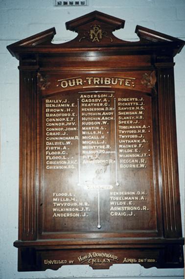 A handsome substantial wooden wall board with carved architrave above the main information area which has three columns of names (45names) beneath the heading “Our Tribute”. Below that are ten more names in two columns. The heading above them is unreadable in the photograph but may be those killed in action.