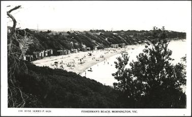 This shows a sweeping view of Fisherman’s Beach for a high point. There are many bathing boxes and people enjoying the day. On the top of the embankment the roofs can be seen of several houses. In the foreground on the right, is a tree top. 