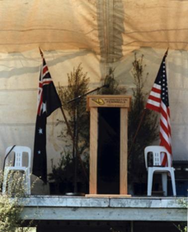Close-up of temporary stage (at Balcombe Army Camp) showing Mornington Peninsula Shire Council lectern flanked by Australian and American flags.