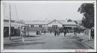 Image shows passengers departing the Railway Station, two horse and buggy cabs waiting in front of the station, to the left of the photo is the Ladies Waiting Room opposite the Blake Street Tea Shop