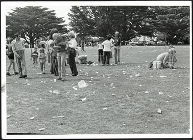 The photo shows members of the public packing up after the picnic in the park, also shown is the amount of rubbish left behind