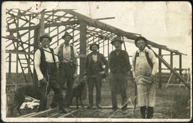 The image shows a party of men erecting the first grandstand at Mornington Racecourse, from L-R 
Chas Thompson, Sam Sherlock, Alan Paterson, John Neilson, 'Nipper' Wilk