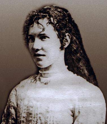 Head and shoulder portrait of a girl in her mid-teens. Her dress is high necked with vertical tucks in the sleeves and bodice. She has long wavy hair.