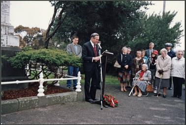 The image is of Neil Taylor from the Mornington Hist. Soc. reading the Remembrance Service at the Memorial, also included in the picture are Stephen Noonan, Rev?, Mrs G. Jordan, Mrs M. McLean, Sgt?, Miss S. Wade