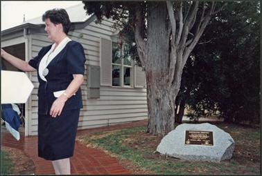 The photo is of Councillor Pat Leech at the Mornington Cemetery Centenary day, to the right of the photo is a plaque commemorating the day
