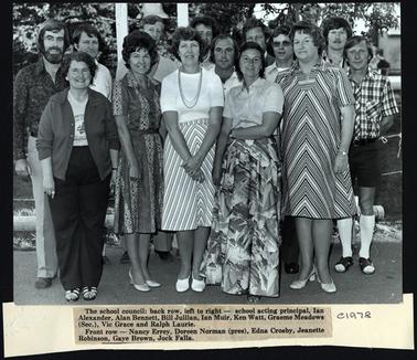 This photograph shows a group of 14 men and women. They are standing in two rows. The photo is accompanied by a news paper cutting showing the names of the group. 